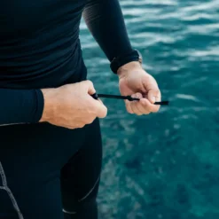 צולל ליד הים קושר את שרוך המותניים במכנסי K2 Medium